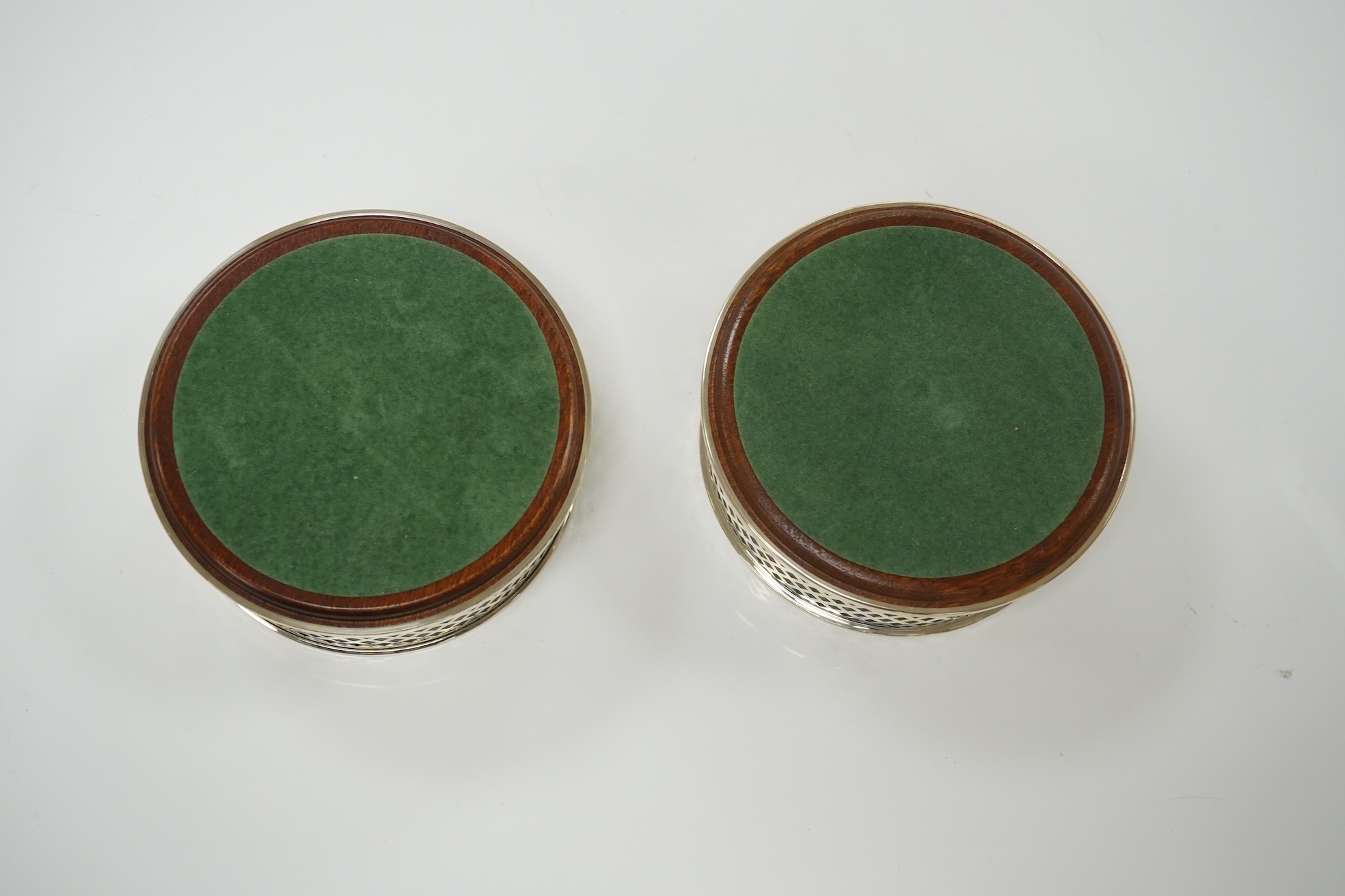A pair of modern pierced silver mounted wine coasters, by W.I. Broadway & Co, Birmingham, 2000, diameter 12.2cm. Condition - good